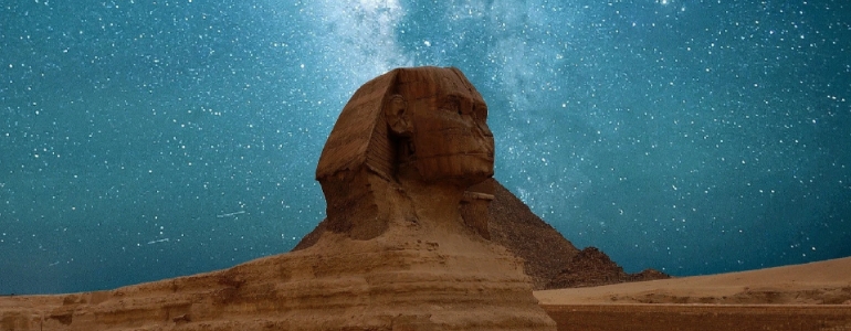 The Great Sphinx of Giza statue in Giza, Egypt under the starry night sky.