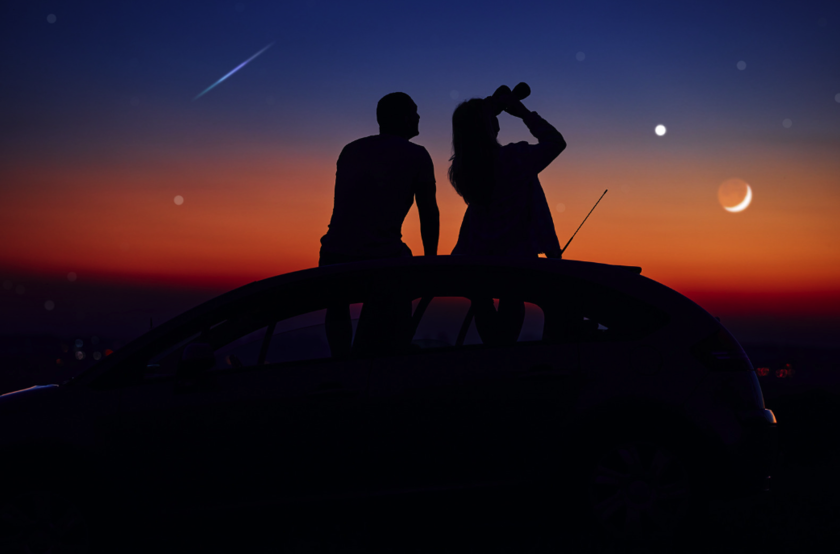 A couple sitting on the car and stargazing with binocular