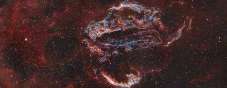 The Cygnus Loop nebula is shining red in outer space.