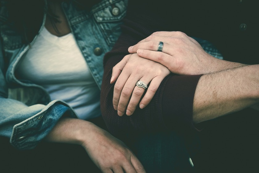 Two people sitting and holding hands