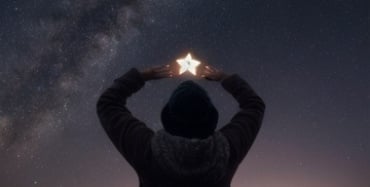 person reaching for a star