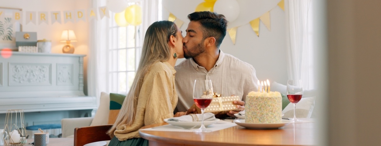A man giving a birthday gift to his wife.