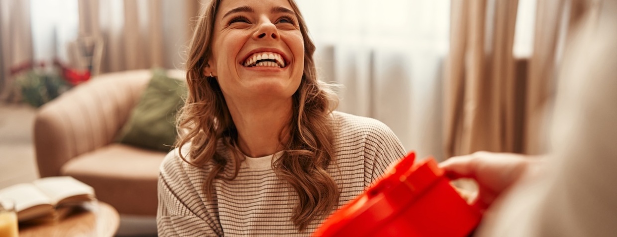 A smiling woman receiving a gift.