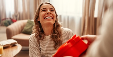 Una donna sorridente che riceve un regalo.