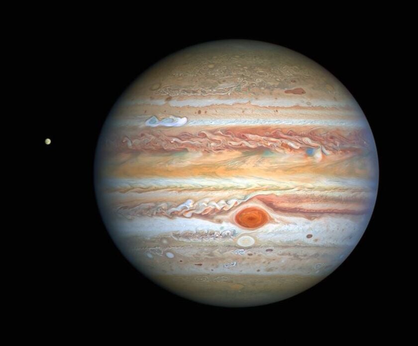 A very detailed photo of Jupiter with a small moon beside it