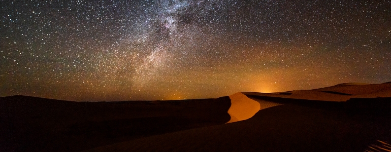 The starry night sky over the sand dunes in the Egyptian desert.