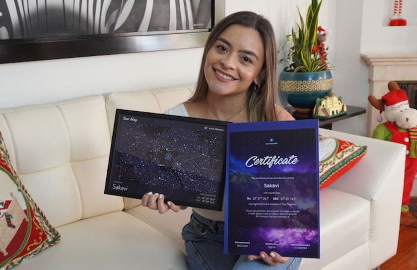 A girl holding a star certificate and a star map