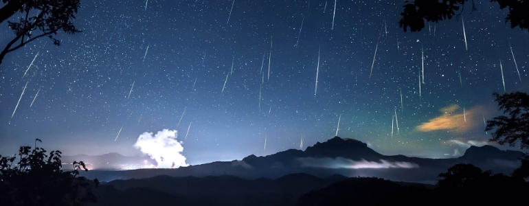 An illustration of a meteor shower in a starry night sky.