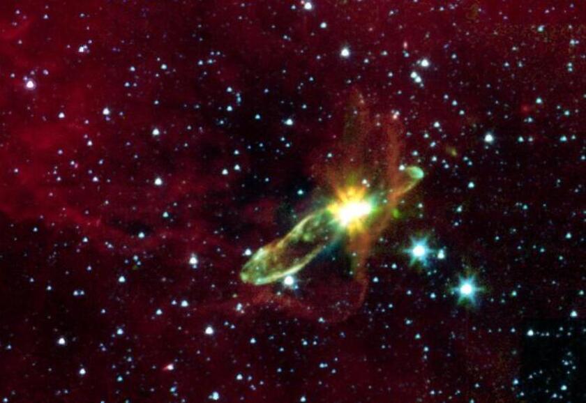 A young star shining brightly green and yellow dust cloud surrounding it