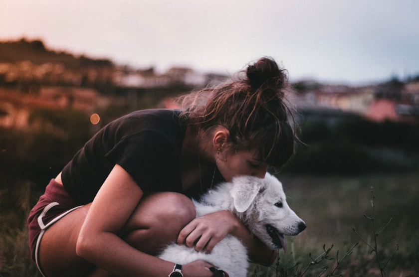 A woman hugging her dog in nature