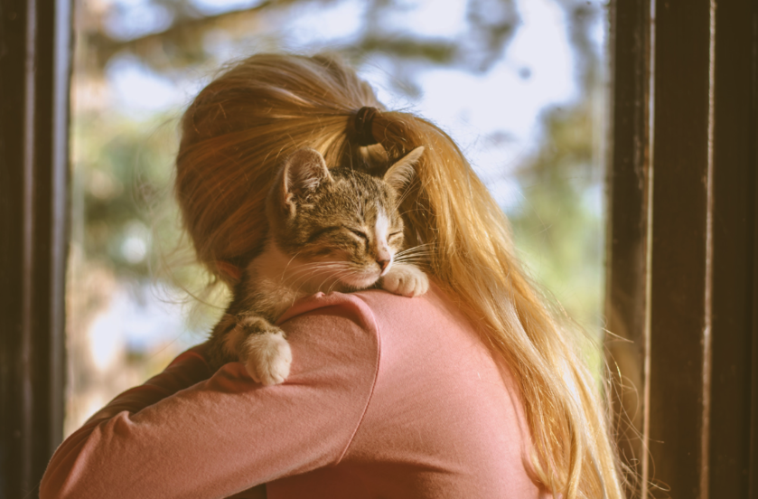 A girl hugging her cat