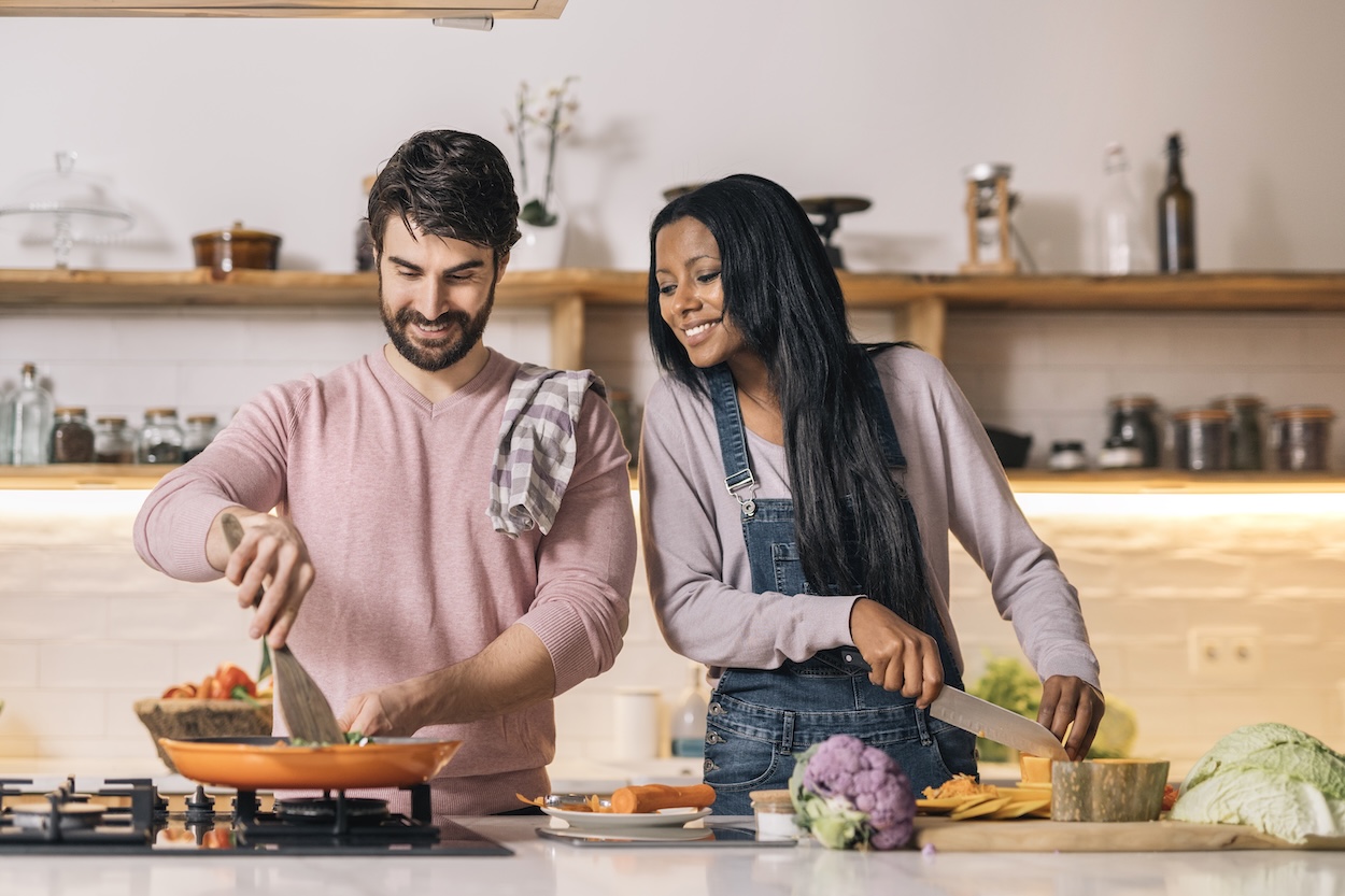 Una pareja joven cocinando en su cocina.