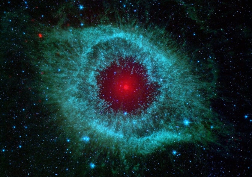 Helix nebula: blue and green dust cloud with a small red star in the middle