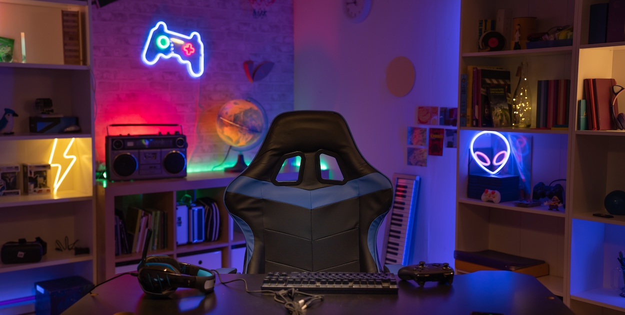 Ein Gaming-Setup zu Hause mit Neonlichtern an der Wand.