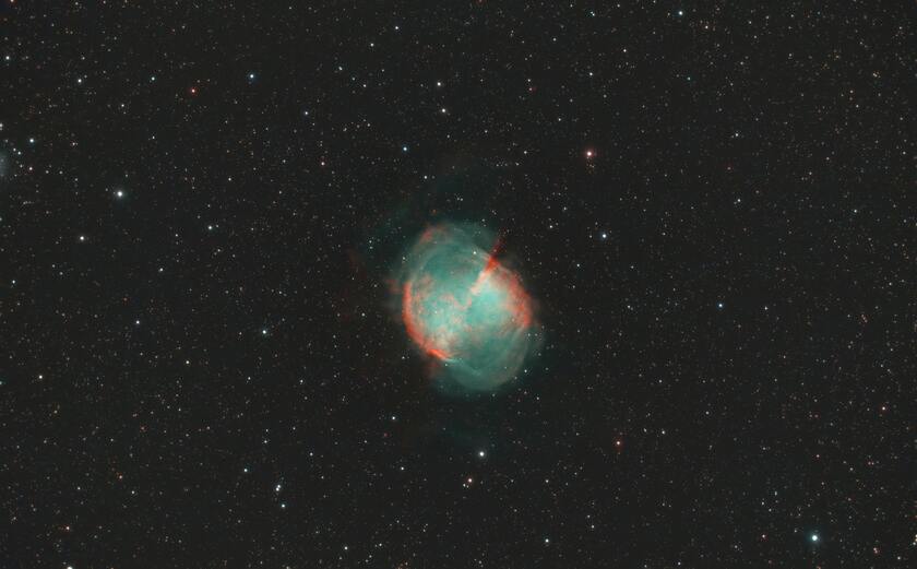 Star exploding into green and orange dust clouds