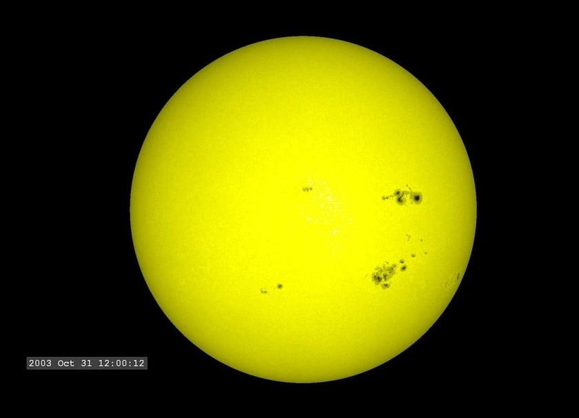 A close up image of the Sun with visible brown spots in its surface