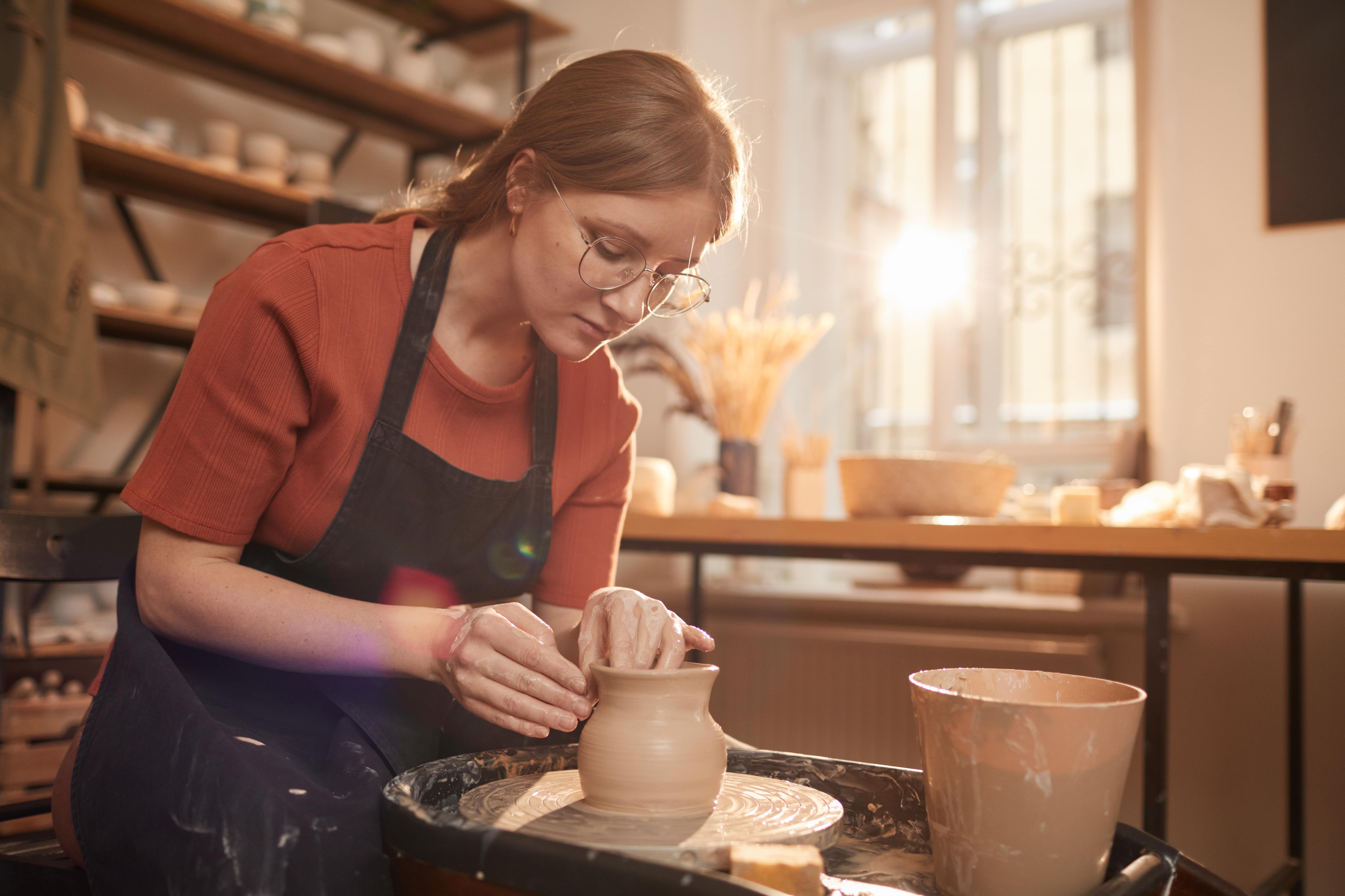 A young woman creating a pottery piece.
